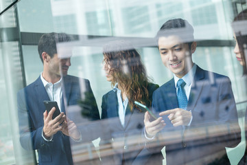 Group of business people discuss somehting on cellphone