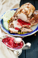 
meat , home baked ham or 
cold boiled pork with spices , lettuce, green peas and sweet and sour berry sauce on a wooden background