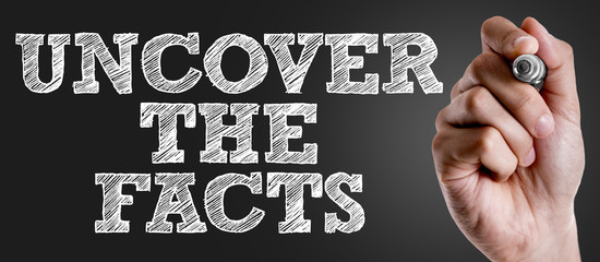 Hand writing the text: Uncover the Facts