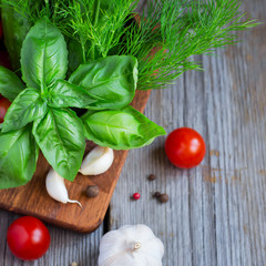 Basil, dill and spices on a wooden background