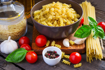 Concept Italy food - pasta, cherry tomatoes, spices on a wooden 