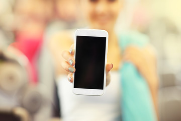 Woman holding smartphone in gym