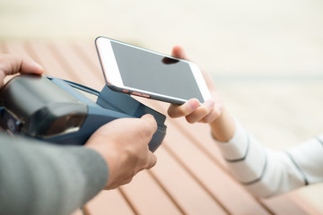 Woman pay by NFC on mobile phone