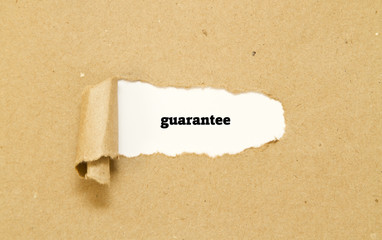 Guarantee word written under torn paper.