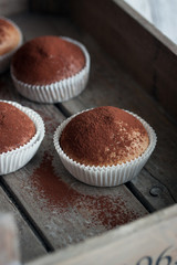 Muffins with spelt flour and cocoa in a wooden box on a table, closeup