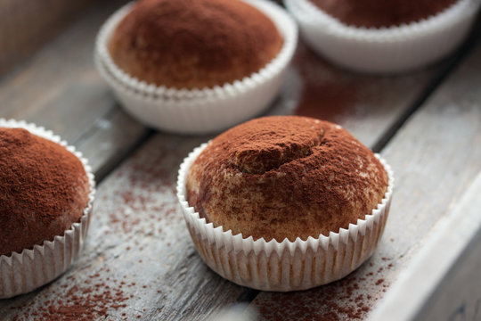 Muffins with spelt flour and cocoa in a wooden box on a table, closeup