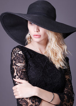 Luxury young woman in a big black hat .