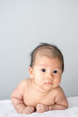 Asian baby lying on stomach