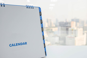 Calendar on the white table with city view background