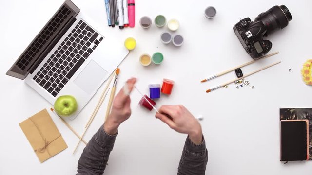 Photographer prepares his desk for work surrounded by a lot of things. Upview