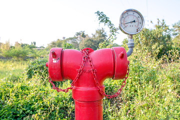 Red metallic fire hydrant with pressure gauge