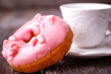 Donut. Sweet food and cup of coffee drink. Rustic wooden table. Bakery, sugar doughnut.
