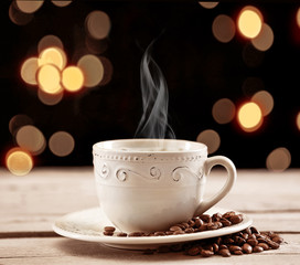 Cup of coffee on table on brown background