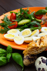 Closeup of boiled quail eggs with bacon and salad. Traditional english breakfast