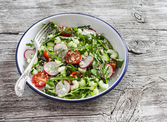 Fresh salad with couscous, tomatoes, cucumber, radish and arugula. Healthy vegetarian food