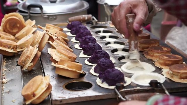 Street food vendor in Taiwan, ROC. Cooking flour stuff with purple yam 