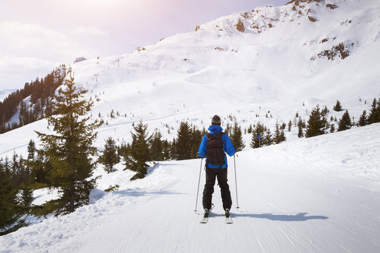 Skier skiing on easy blue trail with beautiful landscape