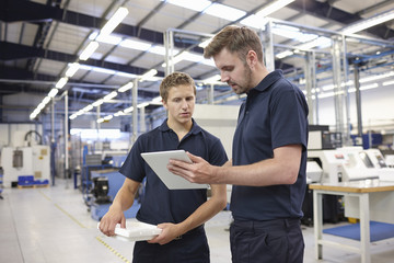 Workers checking order in engineering factory