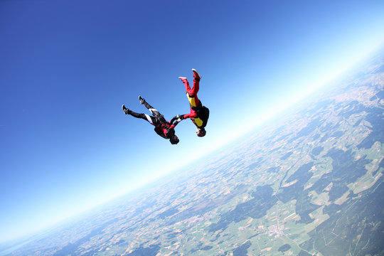 Female skydivers upside down above Leutkirch, Bavaria, Germany