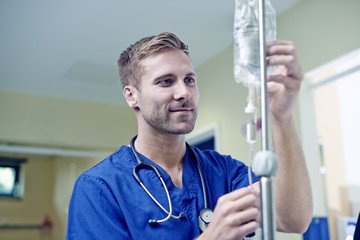 Doctor checking intravenous drip in hospital