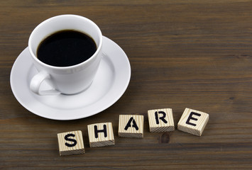 Coffee cup on a wooden table and text - SHARE