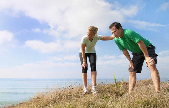 Mid adult couple taking a break from exercise, Thurlestone, Devon, UK