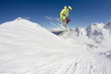 Flying skier on mountains. Extreme winter sport.