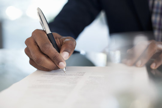 Cropped image of businessman signing paperwork