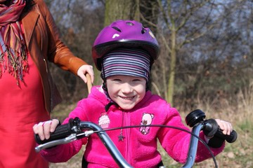 Obraz premium Cute little girl on a bike with her mommy