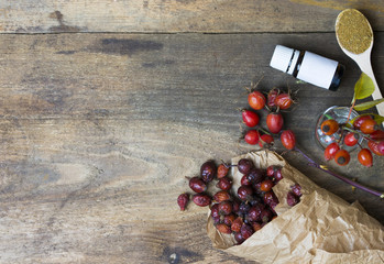 Dog roses and essential oil, bunch of dog rose, Herbal tea, Different types Rosa canina hips and hawthorn, dry goji berries, briar powder in wooden spoon. chinese herbal medicine selection in wooden