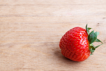 Red fresh strawberry fruit on wooden table.