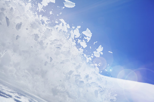 Close up of snow covered hill with powder snow and ice mid air