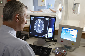 Radiologist looking at brain scan image on computer screen