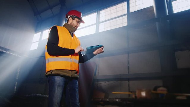 Engineer working with the tablet in a warehouse or factory