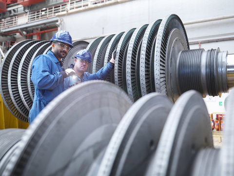  Engineers inspecting turbine during power station outage, portrait