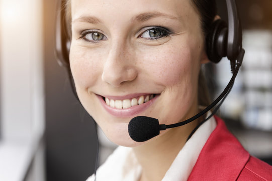 Close up of young businesswoman using telephone headset