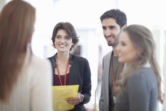Businesswomen and man with paperwork in conference centre atrium