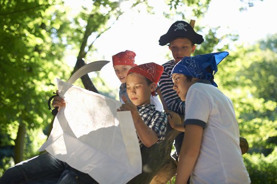 Young boys dressed as pirates, reading map
