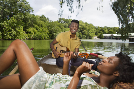 Young couple relaxing in rowing boat on lake in Central Park, New York City, USA
