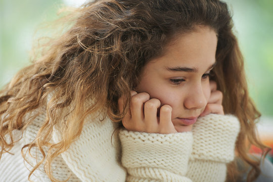 Young girl with brown hair, pensive expression