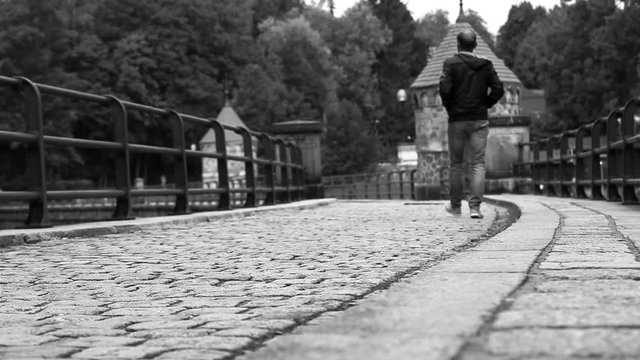 Black and white: man walks along the medieval dam in Liberec (Czech Republic)