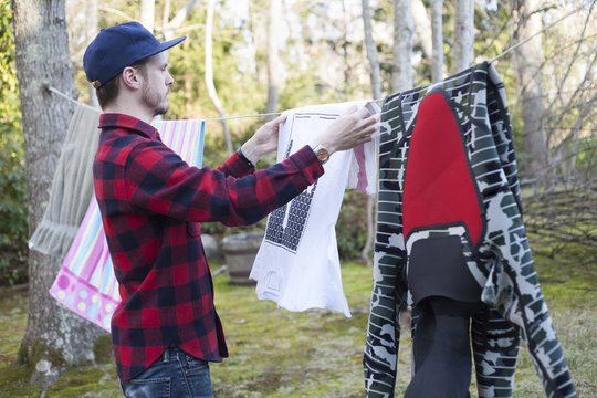 Mid Adult Man Hanging Out Laundry In Garden