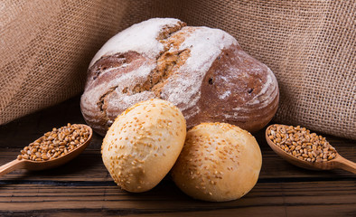 Assortment of baked bread on wooden table background