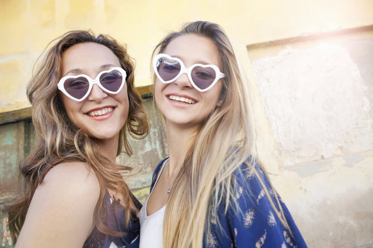 Teenage girls wearing heart-shaped sunglasses