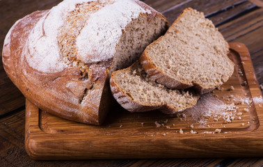 Assortment of baked bread on wooden table background