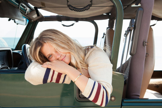 Young woman leaning out of jeep window