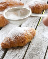 French croissant on a gray wooden surface. Closeup