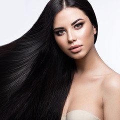 Beautiful brunette girl in move with a perfectly smooth hair, and classic make-up. Beauty face. 