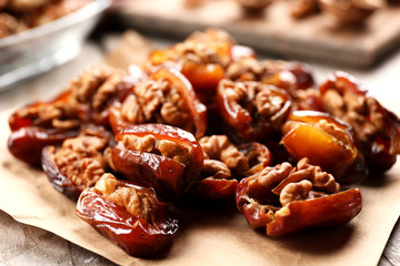 Walnut and date fruit on wooden table, close-up