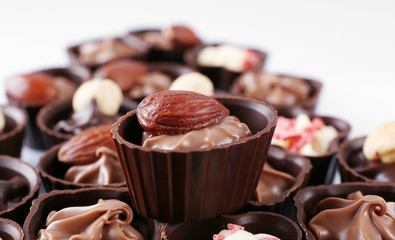 Delicious chocolate candies on white background, close up